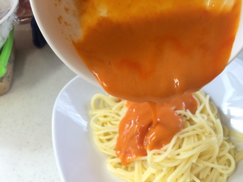 茹で上がったパスタにパスタソースをかける