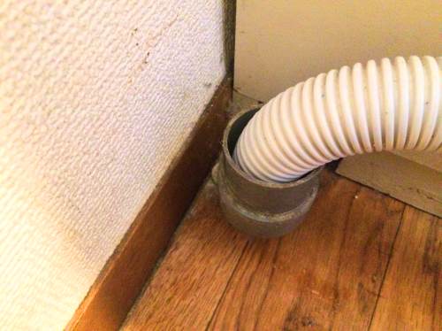 排水溝へ洗濯ホースを入れる